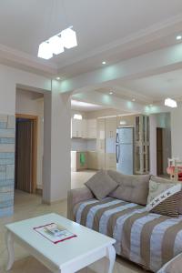 DANA HOTEL APARTMENTs في سارنده: غرفة معيشة بها أريكة وطاولة