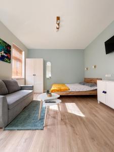 a living room with a couch and a bed at Ozolu apartment in Liepāja