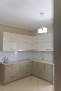DANA HOTEL APARTMENTs في سارنده: مطبخ بخزائن بيضاء ومغسلة +43 صورة
