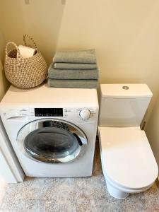 a laundry room with a washing machine and a basket at Ozolu apartment in Liepāja +12 photos