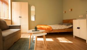 a bedroom with a bed and a couch and a table at Ozolu apartment in Liepāja