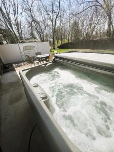 a jacuzzi tub with a bench in a yard at Spanish Style 3-bedroom Home with Hot Tub in Indianapolis