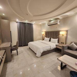 um quarto de hotel com uma cama, um sofá e uma mesa em بلند للشقق المخدومة em Dammam
