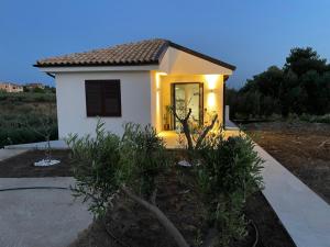 una pequeña casa blanca con luces en un patio en Nella valle dei templi e sul mare, en Villaggio Mosè