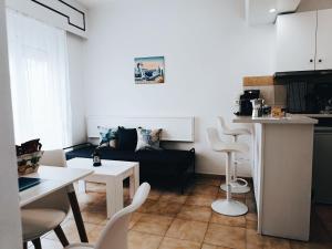 een woonkamer met een bank en een tafel en stoelen bij Nautilus City Studios & Apartments in Rhodos-stad