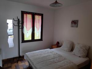 a bedroom with a bed and a window with red curtains at Gite Castillonnes Bastide Périgord 2 Chambres in Castillonnès