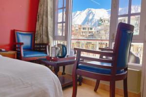 um quarto com 2 cadeiras e vista para uma montanha em Hotel Snow Crest Inn - Natural landscape Mountain View em Dharamshala