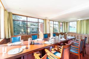 uma grande sala de jantar com uma mesa longa e cadeiras em Hotel Snow Crest Inn - Natural landscape Mountain View em Dharamshala