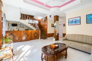 Hotel Snow Crest Inn - Natural landscape Mountain View في دارامشالا: غرفة معيشة مع أريكة وطاولة