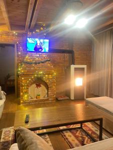 a living room with a brick fireplace with a tv at STANET Forest Houses in Novoberdo