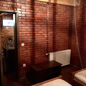 a room with a brick wall with a table in it at STANET Forest Houses in Novoberdo
