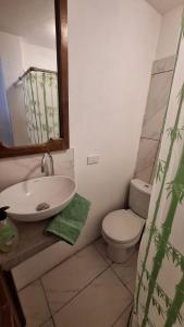 uma casa de banho com um lavatório, um WC e um espelho. em Villa Aventura Lodge em Cajamarca