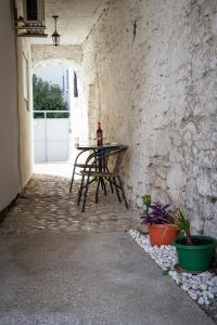 uma mesa e uma cadeira num beco com uma parede de pedra em Studio ADA em Mostar