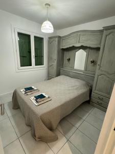 1 dormitorio con 1 cama con 2 toallas en Maison plain pied au calme sur parcelle arborée, en Argelès-sur-Mer