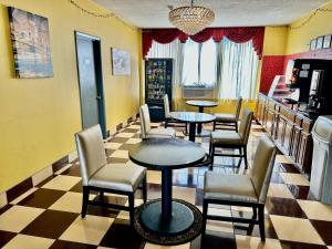 ein Restaurant mit Tischen und Stühlen in einem Zimmer in der Unterkunft Town House Inn and Suites in Elmwood Park