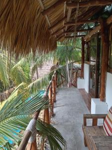 a porch of a resort with palm trees at El Puente in El Paredón Buena Vista