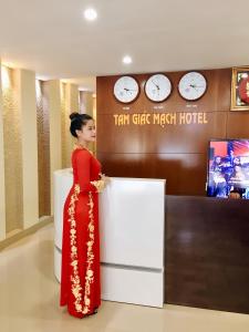 une femme en robe rouge debout dans un hôtel dans l'établissement Tam Giác Mạch Hotel, à Ha Giang