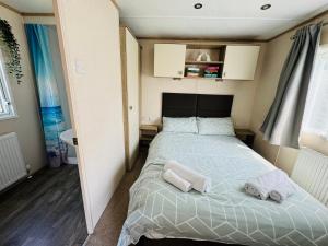 1 dormitorio con 1 cama con 2 toallas en Rosa - Bournemouth Holiday Home, en Wimborne Minster