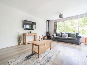 uma sala de estar com um sofá e uma mesa em Cherry - Woodland Cottages em Bowness-on-Windermere
