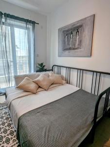 een bed met kussens in een slaapkamer bij Central Apartment, Is-Swieqi in Is-Swieqi