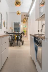 cocina con armarios blancos y comedor en Apartamento Barcelona centro, en Barcelona