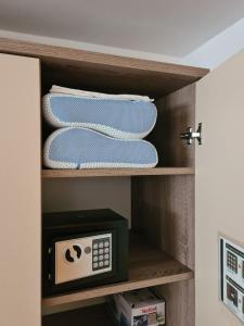 a cupboard with a clock and towels in it at Happy Sparrow in Karlovac