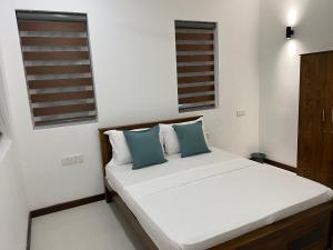 卡圖納耶克的住宿－Silina Airport Residence，卧室内的一张带两个蓝色枕头的床