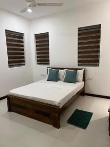 Silina Airport Residence في كاتوناياكى: سرير في غرفة بيضاء مع نافذتين