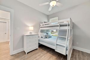 a bedroom with a bunk bed and a ceiling fan at The Perdido Cottage in Pensacola