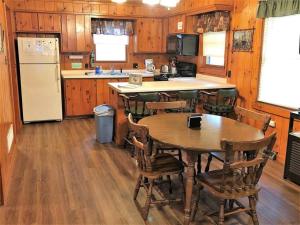 a kitchen with a table and chairs and a refrigerator at Old Stoney's Bass - Big Arbor Vitae Lake in Arbor Vitae