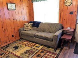 a living room with a couch and a rug at Old Stoney's Bass - Big Arbor Vitae Lake in Arbor Vitae