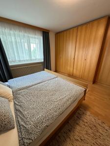 een slaapkamer met een bed en houten kasten bij Kraft tanken in grüner Oase mit großem Wohnraum und riesigem Garten in Dornbirn