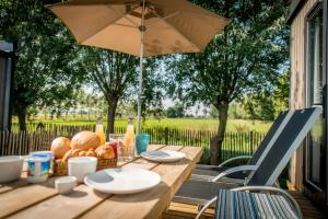 een houten tafel met een parasol op een patio bij Holiday Village Knokke in Knokke-Heist