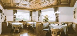 un ristorante con due tavoli e sedie e un soffitto di Garni Le Chalet a Santa Cristina in Val Gardena