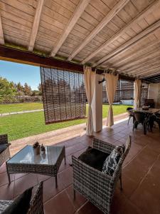 a patio with a couch and chairs and a table at Casa Chiara con accesso diretto alla spiaggia in Àrbatax