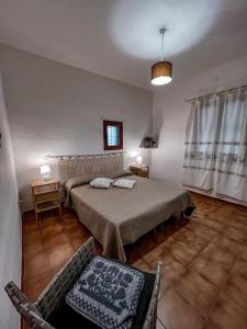 a bedroom with a bed and a chair and a window at Casa Chiara con accesso diretto alla spiaggia in Àrbatax