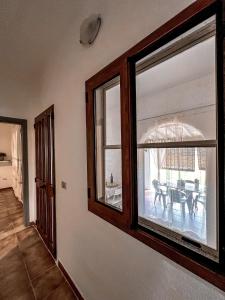 a living room with two windows and a table at Casa Chiara con accesso diretto alla spiaggia in Àrbatax