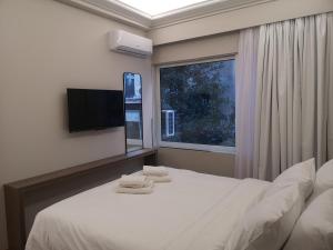 een slaapkamer met een wit bed en een raam bij Athenian Apartments, Syntagma square #6 in Athene