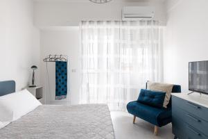 ein Schlafzimmer mit einem Bett und einem blauen Stuhl in der Unterkunft Freshwater Pirates in Gaeta