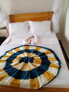 a bed with a colorful blanket on it at CHAMBO VILLAS in Morogoro