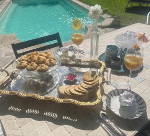 a table with a tray of food next to a pool at chalet sous le chant du chêne in La Roque-dʼAnthéron