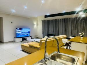 ein Wohnzimmer mit einem Sofa und einem TV in der Unterkunft StoneWall Villa in Mbabane