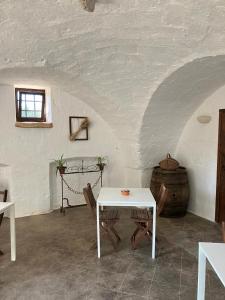 a white table and chairs in a room with a barrel at Masseria Purgatorio in Fasano