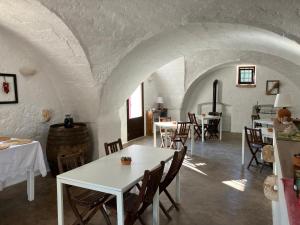 Habitación con mesa, sillas y barril de vino en Masseria Purgatorio, en Fasano