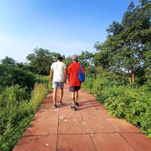 dos hombres caminando por un camino de tierra en Nikunj Dorme, en Rajgir