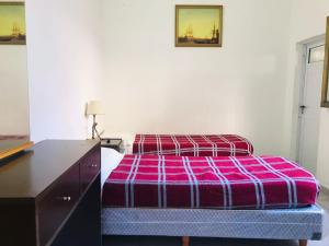 a bedroom with a bed and a dresser with a purple blanket at Hotel Piamonte in Buenos Aires