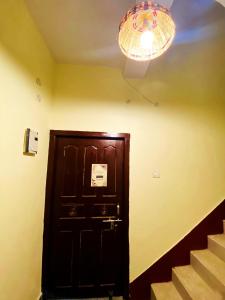 Zimmer mit einer Tür, einer Lampe und einer Treppe in der Unterkunft Nikunj Dorme in Rajgir