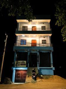 wysoki biały budynek z balkonem na górze w obiekcie Nikunj Dorme w mieście Rajgir