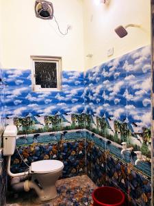 a bathroom with a mural of clouds on the wall at Nikunj Dorme in Rājgīr