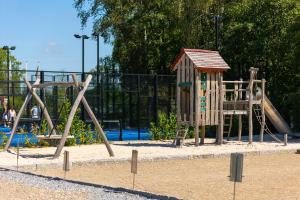a playground with a slide and a swing set at Vakantiehuis Hoge Kempen - 25 minuten Roermond, Maasmechelen & Maastricht in Kinrooi